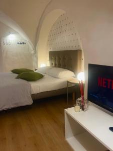 een slaapkamer met een bed en een tafel met een tv bij VagaLuna Short Stay in Catania +40 foto's