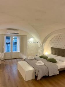 een witte slaapkamer met een groot bed en een tafel bij VagaLuna Short Stay in Catania