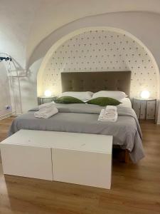 een witte slaapkamer met een groot bed met een groot hoofdeinde bij VagaLuna Short Stay in Catania