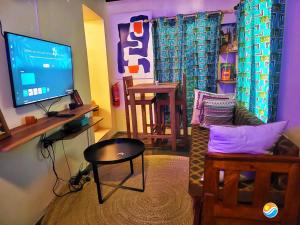 a living room with a tv and a couch and a table at Four Seasons in Stone Town