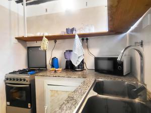 a small kitchen with a sink and a stove at Four Seasons in Stone Town
