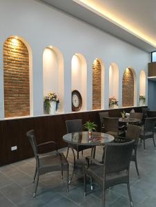un ristorante con tavoli e sedie e un orologio sul muro di KYP Hotel โรงแรมขุนยูวเพลส a Fang