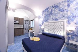 ein blau-weißes Schlafzimmer mit einem Bett und einer Küche in der Unterkunft Appartamenti Amalfi Centro Storico in Amalfi