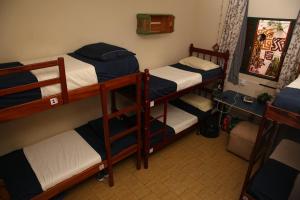 een kamer met 3 stapelbedden in een kamer bij La Chakana Hostel Cultural in Ubatuba