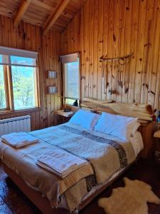 een slaapkamer met een bed in een houten wand bij Parajes del lejano sur Cabaña El Patacón in Moquehue
