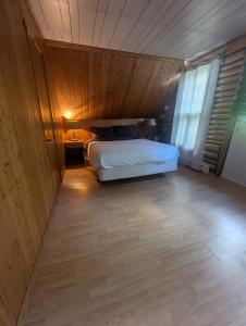 una camera da letto con un letto e una parete di legno di Chalet Lumière a Rawdon