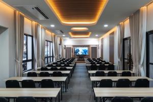 a room with rows of tables and chairs at KYP Hotel โรงแรมขุนยูวเพลส in Fang