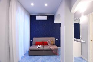 ein Wohnzimmer mit einem Sofa und einer blauen Wand in der Unterkunft Appartamenti Amalfi Centro Storico in Amalfi