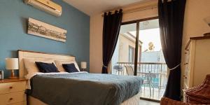 una camera da letto con un letto con pareti blu e una finestra di Kapparis Beach Escape a Paralimni