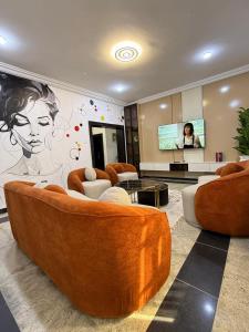 ein Wohnzimmer mit Sofas und einer Zeichnung an der Wand in der Unterkunft Lively Maitama in Abuja