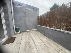 an empty balcony with a wooden floor and a fence at Maison Nomade in Feignies