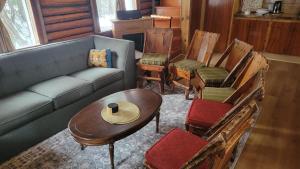 un soggiorno con un divano, sedie e un tavolo di Chalet Lumière a Rawdon