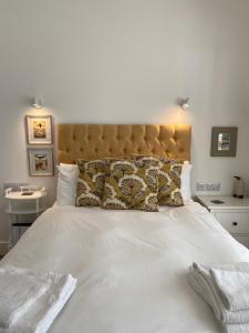 a bedroom with a large white bed with a large headboard at 7 Goathill Crescent in Stornoway +9 photos