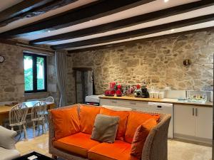 un soggiorno con un divano arancione in cucina di Lime Tree Farmhouse a Saint-Saud-Lacoussière