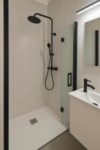 una doccia con una porta in vetro accanto a un lavandino di Uíma River House  Altre 19 foto