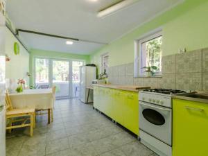 a kitchen with green and yellow appliances and a sink at Leśne Zacisze in Mikoszewo