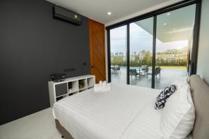 een slaapkamer met een groot wit bed en een balkon bij The Stay Huahin 2 - Luxury Private Pool Villa in Khao Tao
