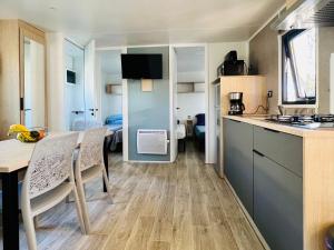 a kitchen with a table and chairs in a room at MobilHomeTorreilles in Torreilles
