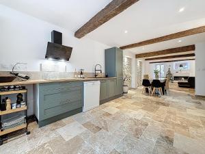 a kitchen with green cabinets and a dining room at Cottages Occitans in Villepinte