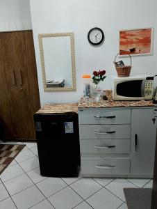 a kitchen with a microwave and a counter top with a microwave at Suite do lar in Timbó