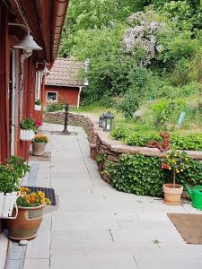 een tuin met bloempotten en een gebouw bij Unikt sommarboende in Färjestaden