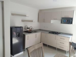 eine Küche mit weißen Schränken und einem Edelstahlkühlschrank in der Unterkunft House B Residential condominium with pool in Miranda