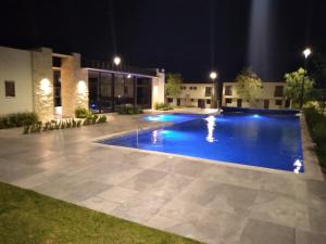 a swimming pool at night in front of a building at House B Residential condominium with pool in Miranda