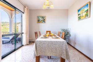a dining room with a table and a balcony at Estrela House I Calheta Madeira in Calheta +22 photos