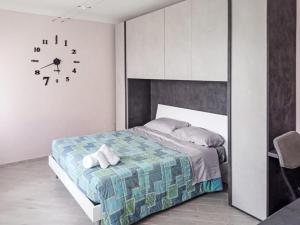 ein Schlafzimmer mit einem Bett und einer Uhr an der Wand in der Unterkunft Villa Maria in Castelletto Soprano