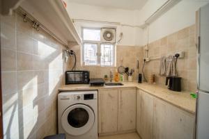 a small kitchen with a washing machine in it at Huge Studio and Rooftop in Central in Hong Kong