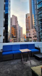 a blue bench sitting on a rooftop with a table at Huge Studio and Rooftop in Central in Hong Kong