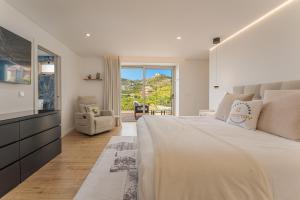a bedroom with a large bed and a television at The Viewpoint by Eurostay in Ribeira Brava