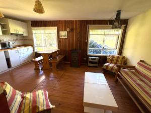 een woonkamer met een bank en een tafel bij Departamento tranquilo y equipado en parcela privada, cerca de comercios in Puerto Montt +10 foto's