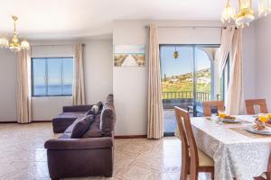 a living room with a couch and a table at Estrela House I Calheta Madeira in Calheta
