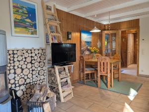 a kitchen and dining room with a table and a television at Kysthus in Damp