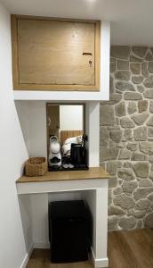 a counter with a microwave and a stone wall at B&B Dimora della Fonte in Roccaraso