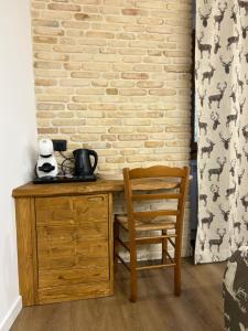 a wooden desk with a chair next to a brick wall at B&B Dimora della Fonte in Roccaraso