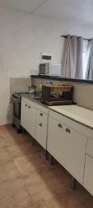 a kitchen with white cabinets and a stove at Terrazas al Sol 03 in Playa Hermosa