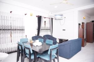 a dining room with a table and blue chairs at Dilithy Paradise in Trincomalee +11 photos