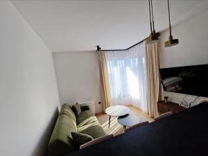 un salon avec un canapé vert et une table dans l'établissement Infinity Apartment & Privat Garage, à Sarajevo