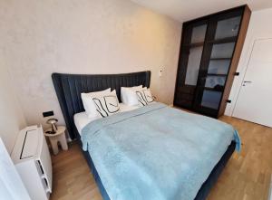 une chambre avec un grand lit avec une couverture bleue dans l'établissement Infinity Apartment & Privat Garage, à Sarajevo