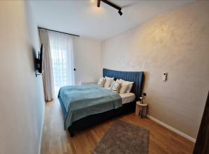 - une chambre avec un lit doté d'une couverture bleue et d'oreillers dans l'établissement Infinity Apartment & Privat Garage, à Sarajevo
