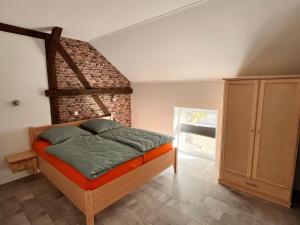 a bedroom with a bed and a brick wall at Seeidyll Potzlower See in Potzlow