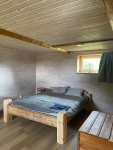 een bed in een kamer met een houten plafond bij Vesilinnu in Aabla