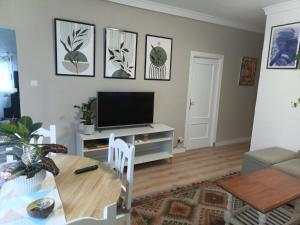 a living room with a table and a television at Villasultana 1 in Chipiona