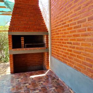 a brick wall with a pizza oven on a patio at Complejo Ayllu in Las Rabonas