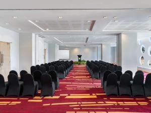 a conference room with black chairs and a red carpet at Ibis Styles Malang in Malang +72 photos