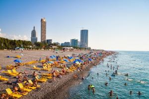 a beach with a crowd of people in the water at Batumi Inn Hotel in Batumi
