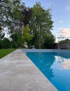 une piscine avec de l'eau bleue et des arbres dans l'établissement Le Petit Lavoir - Joli studio à Mayet, à Mayet