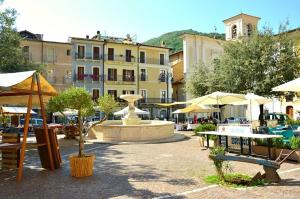 a courtyard with a fountain and tables and umbrellas at Casa Vacanze Giano in Antrodoco